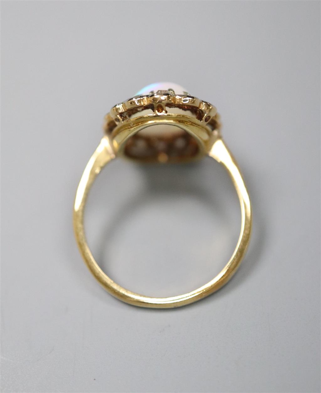 An early to mid 20th century 18ct, white opal and diamond set oval cluster ring, size K, gross 3.1 grams.